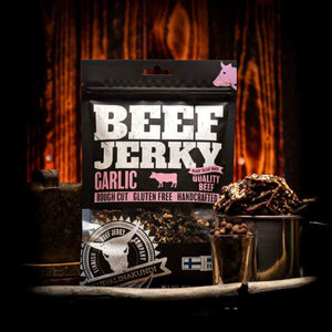 Kuivalihakundi Beef Jerky med Hvitløk foran flammer, med stålkopp fylt med biter