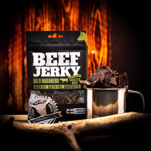 Kuivalihakundi Beef Jerky Mild Habanero foran flammer, med stålkopp fylt med biter