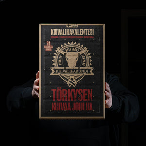 Hender holder opp Kuivalihakundi Jerky julekalender med sine 24 luker i et mørkt rom