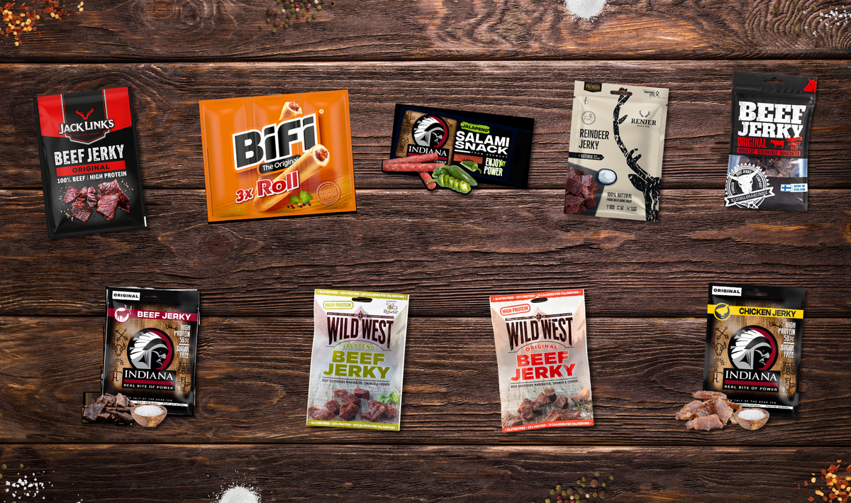 Et utvalg av beef jerky og kjøttsnacks fra flere merker på et trebord