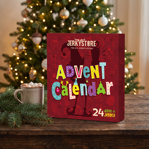 Jerky Store julekalender på et trebord med granbar, en kopp kakao og juletre i bakgrunnen