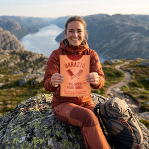 Turgåer tar en pause på fjellet og holder Barazzo Tørket Svinefilet BBQ, AI-generert bilde