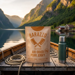 Barazzo Tørket Svinefilet Honning & Sennep på dekket av en liten båt på fjorden, med tau og termos i kveldssol, AI-generert bilde