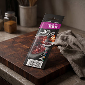 JerkyShop Biff Bar BBQ på en mørk skjærefjøl på kjøkkenbenken i dempet vinduslys, AI-generert bilde