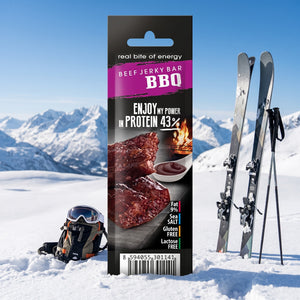 JerkyShop Biff Bar BBQ i snøen ved siden av turski og staver på en solrik vinterdag i fjellet, AI-generert bilde