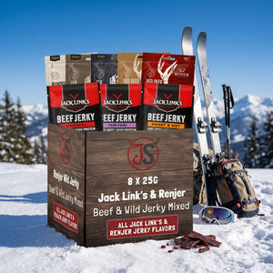 Beef & Beyond Box - Jack Link's & Renjer Mix i snøen ved siden av turski og staver på en solrik vinterdag i fjellet, AI-generert bilde