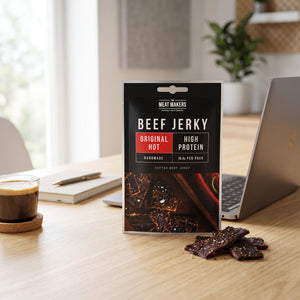 Meat Makers Beef Jerky Hot på skrivebordet ved siden av laptop, kaffekopp og notatbok, AI-generert bilde