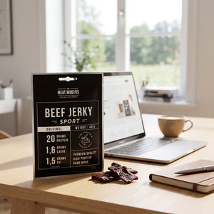 Meat Makers Sports Beef Original på skrivebordet ved siden av laptop, kaffekopp og notatbok, AI-generert bilde