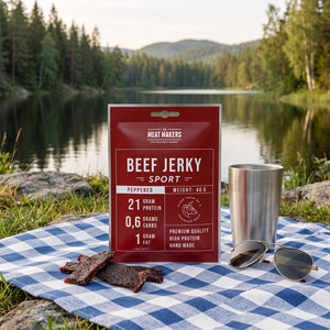 Meat Makers Sports Okse med Pepper på et rutete piknikteppe ved et skogsvann en sommerdag, med stålkopp og solbriller, AI-generert bilde