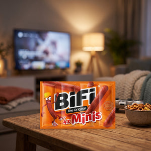 BiFi Minis 4-pack på stuebordet en kveld, med spillkontroll og en liten skål, AI-generert bilde