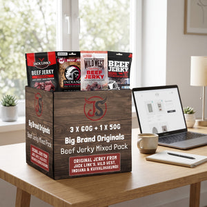 Big Brand Originals Beef Jerky Mixed Pack på skrivebordet ved siden av laptop, kaffekopp og notatbok, AI-generert bilde