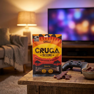 Cruga Biltong Chili på stuebordet en kveld, med spillkontroll og en liten skål, AI-generert bilde