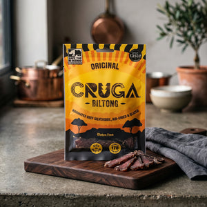 Cruga Biltong Original på en mørk skjærefjøl på kjøkkenbenken i dempet vinduslys, AI-generert bilde