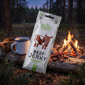 Fine Gusto Beef Jerky Pepper på en stokk ved bålet i furuskogen i skumringen, med emaljekopp og kuksa, AI-generert bilde
