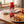 Hela Curry Ketchup Original ved en tallerken med oppskåret grillpølse, currysaus og pommes frites, AI-generert bilde