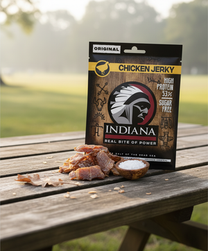 Indiana Kylling Jerky Original på et piknikbord i morgensol, med jerkybiter ved posen, AI-generert bilde