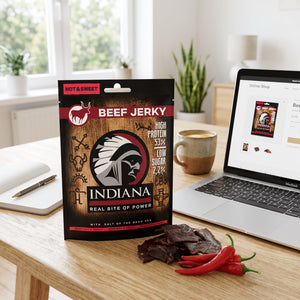 Indiana Beef Jerky Hot & Sweet på skrivebordet ved siden av laptop, kaffekopp og notatbok, AI-generert bilde
