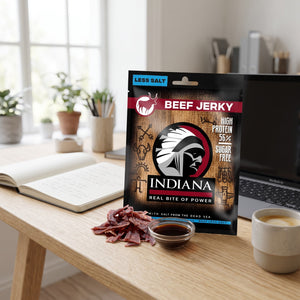 Indiana Beef Jerky Mindre Salt på skrivebordet ved siden av laptop, kaffekopp og notatbok, AI-generert bilde