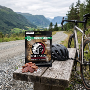 Indiana Kalkun Jerky Original på en benk ved grusveien, med sykkel og sykkelhjelm, AI-generert bilde