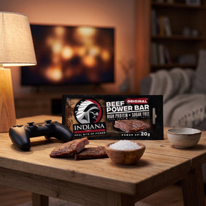 Indiana Beef Bar Original på stuebordet en kveld, med spillkontroll og en liten skål, AI-generert bilde