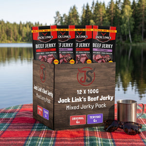 Jack Link's Beef Jerky Mix på et rutete piknikteppe ved et skogsvann en sommerdag, med stålkopp og solbriller, AI-generert bilde