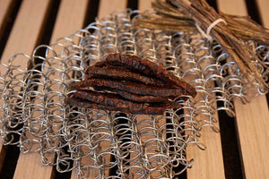 KJØ beef jerky til tørk på en rist av ståltråd på et trebord