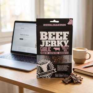 Kuivalihakundi Beef Jerky med Hvitløk på skrivebordet ved siden av laptop, kaffekopp og notatbok, AI-generert bilde