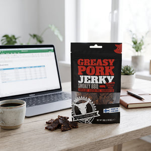 Kuivalihakundi Greasy Pork Jerky Røkt BBQ på skrivebordet ved siden av laptop, kaffekopp og notatbok, AI-generert bilde
