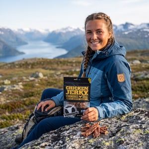 Turgåer tar en pause på fjellet og holder Kuivalihakundi Kylling Jerky med Sitrongress, AI-generert bilde