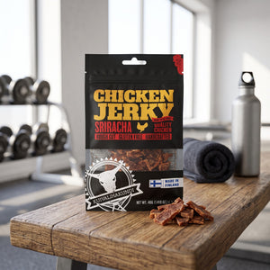 Kuivalihakundi Kylling Jerky Sriracha på en benk på treningssenteret, med manualer, håndkle og drikkeflaske i bakgrunnen, AI-generert bilde