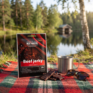 Meat Makers Beef Sweet Chilli Gourmet på et rutete piknikteppe ved et skogsvann en sommerdag, med stålkopp og solbriller, AI-generert bilde