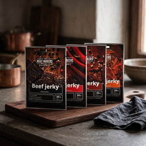 Meat Makers Gourmet Pakkepris på en mørk skjærefjøl på kjøkkenbenken i dempet vinduslys, AI-generert bilde