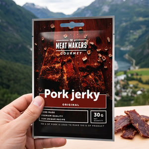 Hånd som holder Meat Makers Pork Original Gourmet foran et fjordlandskap, AI-generert bilde