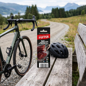 JerkyShop Biff Bar Pepper på en benk ved grusveien, med sykkel og sykkelhjelm, AI-generert bilde