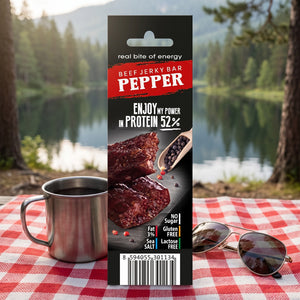 JerkyShop Biff Bar Pepper på et rutete piknikteppe ved et skogsvann en sommerdag, med stålkopp og solbriller, AI-generert bilde