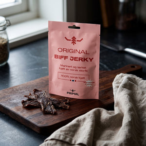 Primal Original Norsk Beef Jerky på en mørk skjærefjøl på kjøkkenbenken i dempet vinduslys, AI-generert bilde