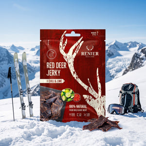 Renjer Hjort Jerky med Chili & Lime i snøen ved siden av turski og staver på en solrik vinterdag i fjellet, AI-generert bilde