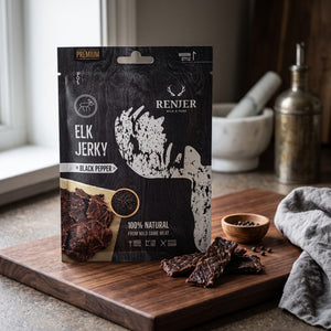 Renjer Elg Jerky med Svart Pepper på en mørk skjærefjøl på kjøkkenbenken i dempet vinduslys, AI-generert bilde