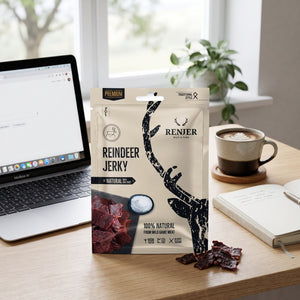 Renjer Reinsdyr Jerky med Sjøsalt på skrivebordet ved siden av laptop, kaffekopp og notatbok, AI-generert bilde
