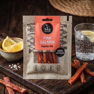 Sea Snacks tørket laks på en mørk fjøl med sitronbåter og et glass farris, AI-generert bilde