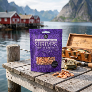 Sea Snacks tørket reker fra Grønland på en brygge i et fiskevær, med fiskestang og redskapsboks, AI-generert bilde