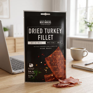 Meat Makers Tørket Kalkun Filet på skrivebordet ved siden av laptop, kaffekopp og notatbok, AI-generert bilde
